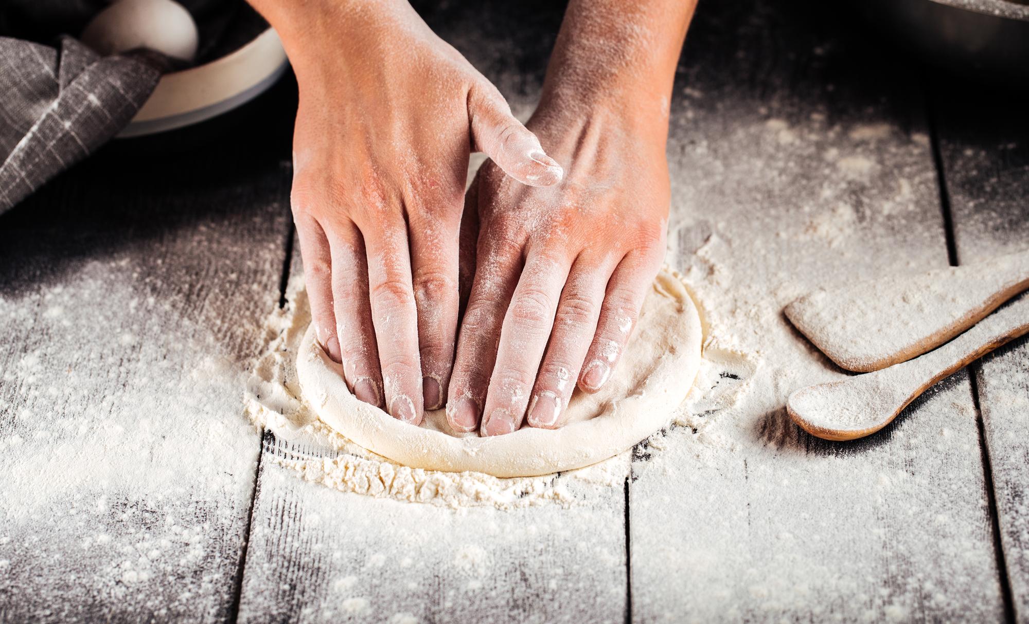 Hands shaping dough in workshop